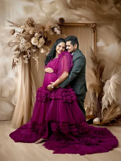 An intimate embrace between the couple. This pose highlights their close bond and the shared excitement of their journey to parenthood, framed by the beautiful gown and backdrop.