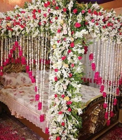 We create romantic settings for your wedding night. This four-poster bed is lavishly decorated with a canopy of white and red flowers and hanging floral strings for an unforgettable first night.