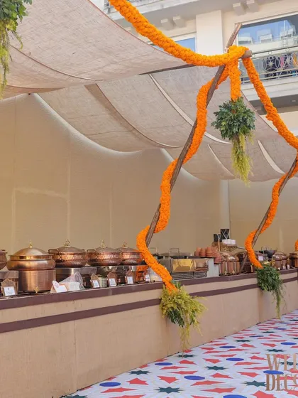 The buffet line setup, with traditional copper serveware that complements the rustic theme. The decor extends even to the functional areas of the party.
