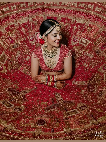 A bride's portrait is more than a photo; it's a timeless piece of art. Here, we captured Kriti in her magnificent red lehenga, showcasing the intricate details of her attire and the joyful anticipation in her smile.