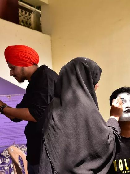 Volunteers getting ready for a mime performance. This behind the scenes shot shows the teamwork and creativity that goes into our events.