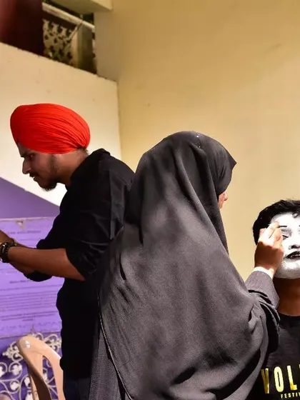 Volunteers help a mime artist prepare for his performance at Sign Fest. Our community is a collaborative space where different art forms come together for a cause.