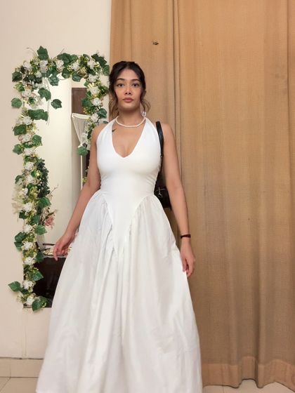 A full-length view of the white halter dress, showing off its beautiful flow and structure. It’s a truly timeless piece.