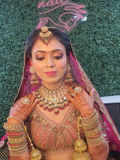 A detailed shot of the bridal makeup, focusing on the soft cut-crease eyeshadow with a hint of shimmer and a flattering pink lip tone. The makeup is set to be long-lasting and picture-perfect.