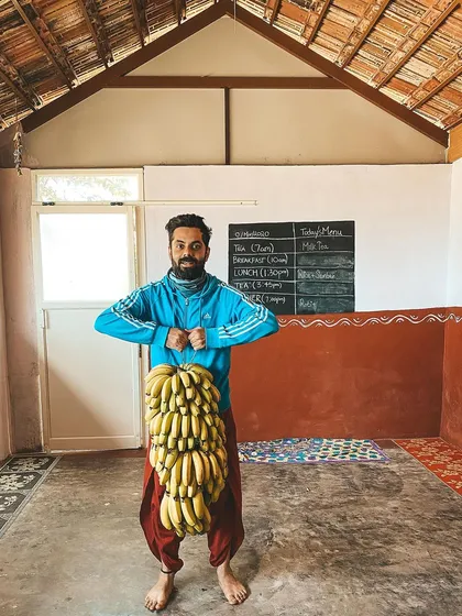Our food is simple, fresh, and often grown right here at the ashram. Holding a bunch of bananas from our garden is a joyful reminder of nature's abundance.