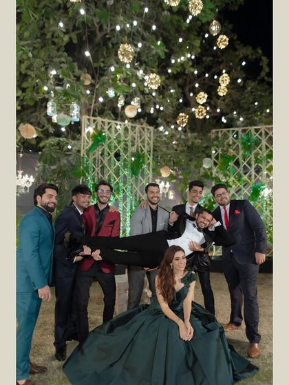 The groomsmen having fun with the groom. This candid shot shows the camaraderie and playful energy of the groom and his friends during the reception.