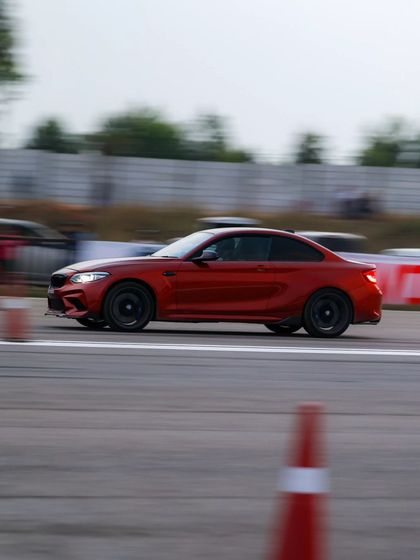 A red BMW M2 coupe, a compact performance powerhouse, captured in a motion blur. The variety of BMW's M cars at our events is always impressive.