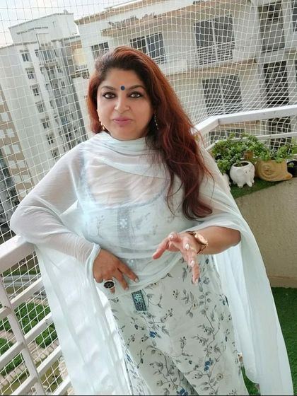 A happy client posing in the light blue floral suit we customized for her.