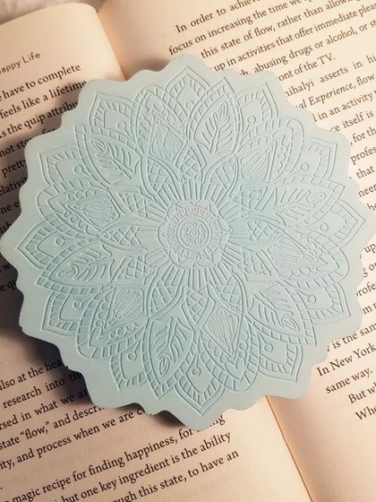 A direct overhead shot of the icy blue Mandala coaster, showing the crispness of the pattern.