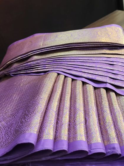 A close-up showing the beautiful texture and pleats of the lavender silk saree.