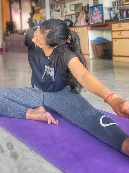 A closer look at a student in a seated forward bend and twist. I encourage mindful movement, paying attention to the details of each stretch to maximize benefits and prevent injury.