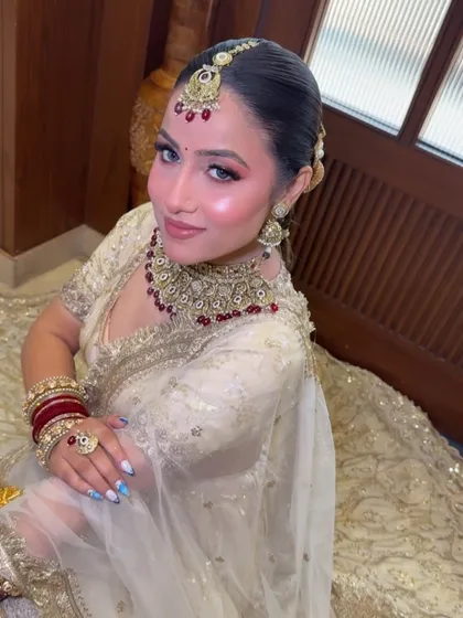 A beautiful seated pose of the model from our Amritsar Masterclass, showing off the full bridal ensemble and the radiant makeup.