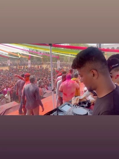 A side view from the console, focused on the massive crowd of people dancing and celebrating Holi. This is what a successful daytime music festival looks like.