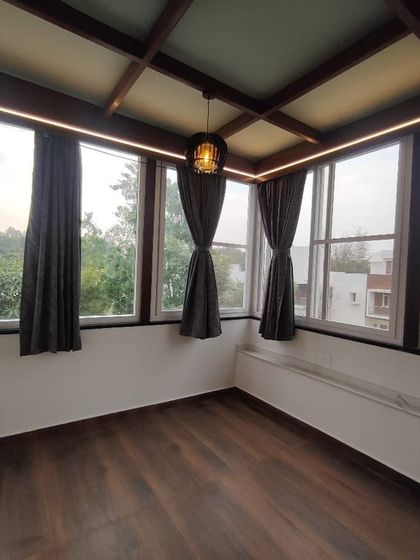 An interior view of a sunroom we constructed. Featuring a wood-beamed glass ceiling and large windows on all sides, this space is designed to be a bright and peaceful retreat with panoramic views of the outdoors.