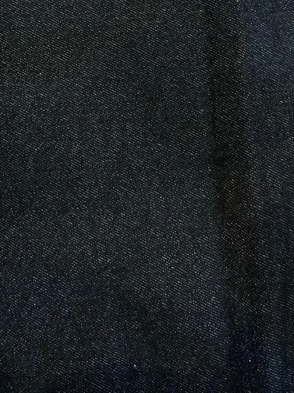 A swatch of pure black, non-stretch denim. This is a versatile choice for creating sleek custom jeans, jackets, or even trousers.