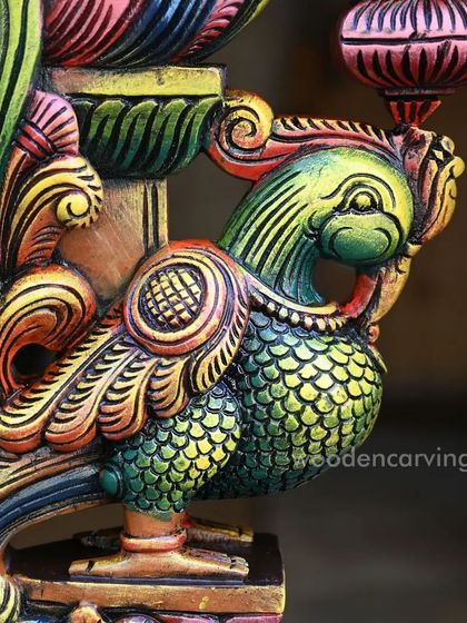 A detailed close-up of the head and neck of the colorful Annapakshi bracket. The blend of green, yellow, and red hues creates a lively and eye-catching effect.