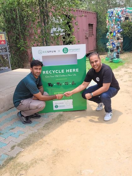Two of our partners celebrate the launch of a new clothing recycling bin. This collaboration is key to our mission of giving every piece of clothing a second chance.