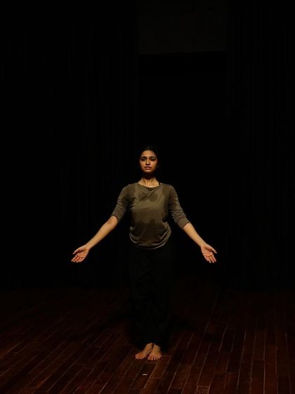 A dancer in a moment of stillness during a tech run.