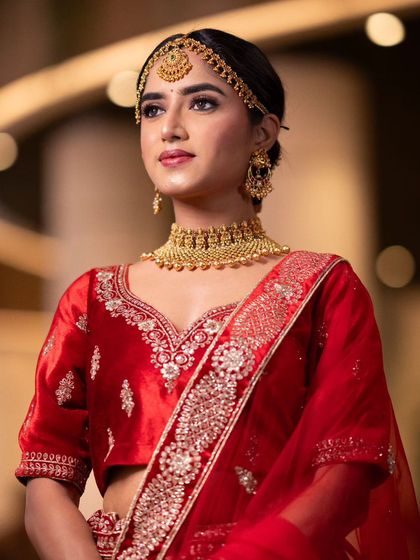 A three-quarter profile, showcasing the elegant updo and the flawless base makeup.