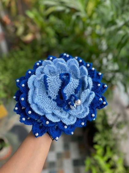 A stunning blue floral Kanha Ji dress. The layered petals and pearl details create a beautiful, blooming effect.