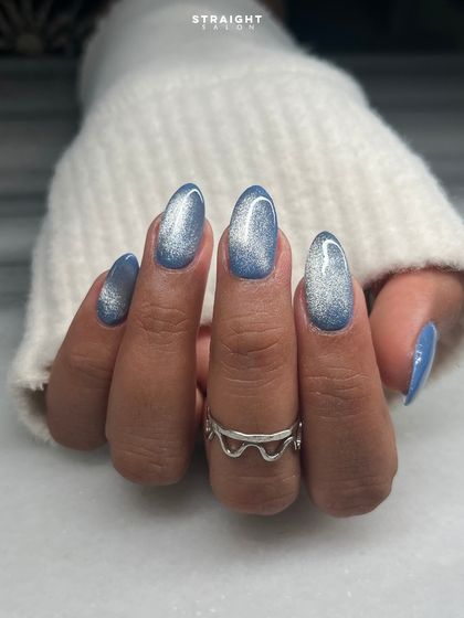A beautiful blue and silver cat-eye effect on natural oval nails. This magnetic polish creates a galaxy-like shimmer that is both dreamy and sophisticated.
