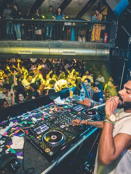 A high-angle shot showing me on the mic, overlooking a packed dance floor. I make sure to engage with every corner of the room.