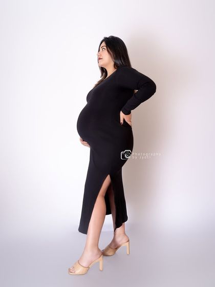 A modern and confident pose in a simple black dress. This style is perfect for moms-to-be who want a minimalist and fashionable maternity shoot.