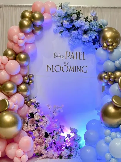 The stunning pink and blue balloon arch under dramatic lighting, creating the perfect photo opportunity for a gender reveal party.