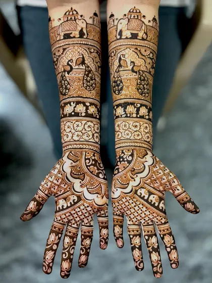 For the bride who loves classic elegance, this design is a perfect choice. It features majestic peacocks and royal elephants, symbols of grace and strength, woven into a traditional full-coverage pattern that extends up the forearms.