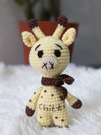 A custom giraffe doll named 'Chilli', complete with a cozy scarf.