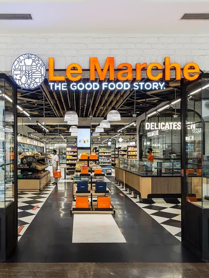 The entrance to Le Marche gourmet food store is designed to feel like a modern, organized marketplace. The clear branding and open facade invite customers into a space that promises a vibrant and engaging shopping experience.