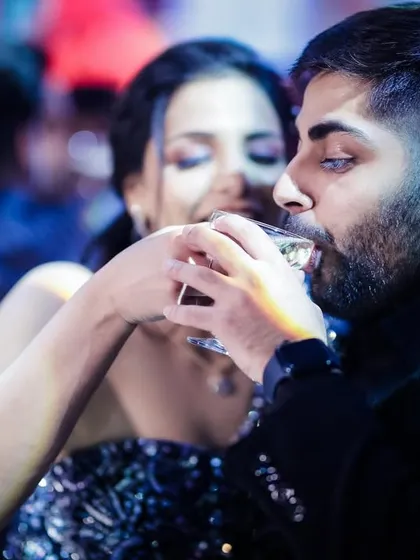 A candid shot of the couple sharing a drink during their cocktail party.