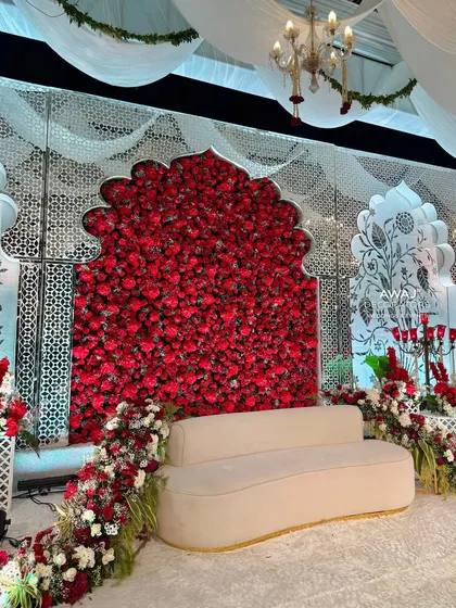 Another perspective of the stage, highlighting the interplay between the solid red floral wall and the delicate white latticework.