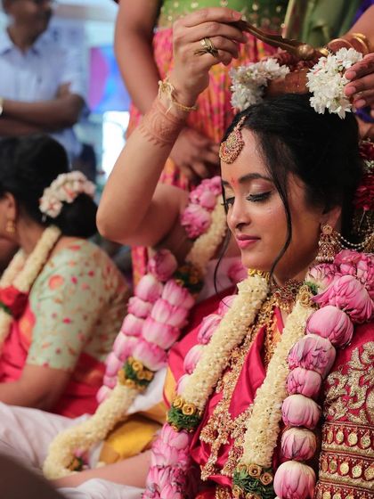 A beautiful moment of blessing during an Iyer wedding. The bride's makeup is kept soft and subtle, with fresh flowers in her hair completing the look.