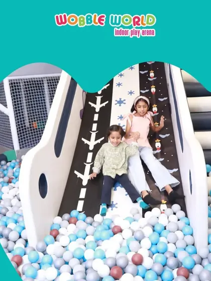 Double the fun! Two friends sliding down together into the soft landing of the ball pit. It's a perfect spot for playdates and making new friends.
