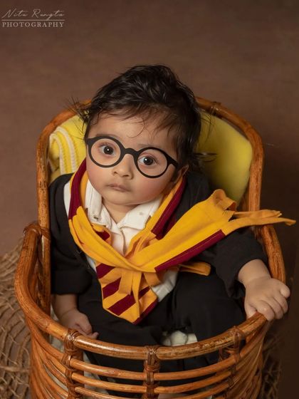 The cutest wizard in training. This baby Harry Potter shoot captures the adorable side of magic, complete with tiny glasses and a Gryffindor scarf.