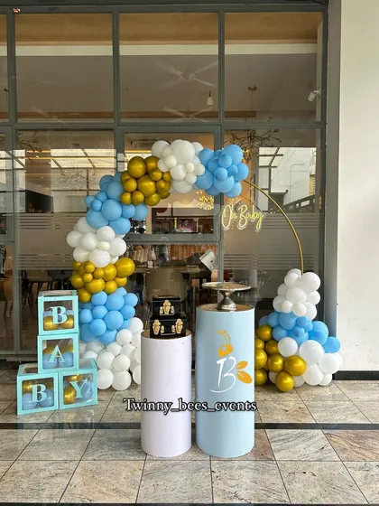 Here is a blue, white, and gold themed baby shower setup we did outdoors. It features a balloon arch, "BABY" display boxes, and matching pedestals, creating a clean and elegant look for welcoming a baby boy.