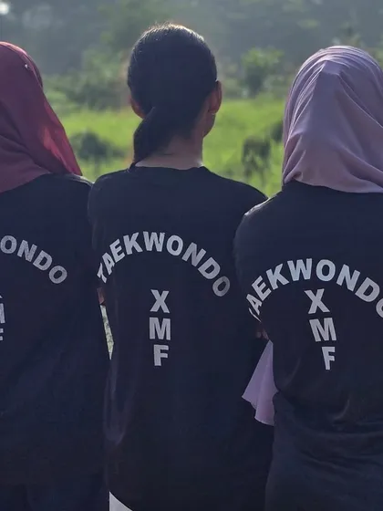 Our team identity. Female students proudly wearing the XMF Taekwondo team shirts.