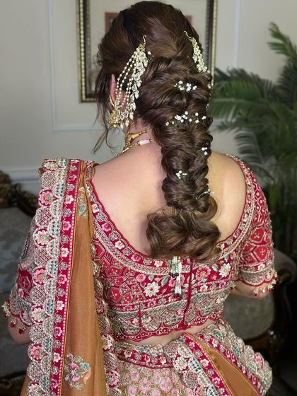 This voluminous, messy fishtail braid is perfect for a bride who wants a romantic and slightly undone look. I added strands of pearls and a traditional 'passa' for a touch of glamour.