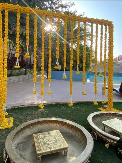 For this outdoor Haldi ceremony, I designed a beautiful backdrop using curtains of fresh marigold flowers. The setup includes traditional brass urlis and ornate chowkis, creating a perfect blend of elegance and festive tradition for the bride's haldi.