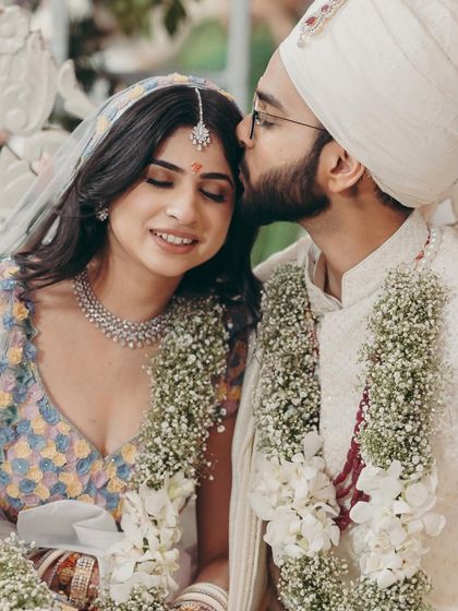A tender moment between the bride and groom. The soft makeup enhances the romantic mood of the picture.
