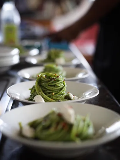 A line of perfectly twirled pasta dishes ready for service. This is what it looks like to cook like a professional.