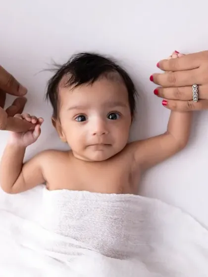 Tiny hands held in the loving grasp of mom and dad. This pose is a beautiful way to show the scale of how small your newborn is and the powerful bond that has just begun. It's a must-have shot in my newborn family sessions.