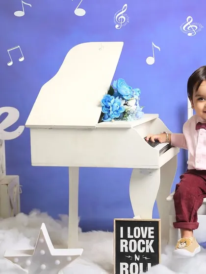 A little musician at his piano. This music-themed first birthday shoot is a creative way to celebrate a milestone, complete with a mini grand piano and musical notes.