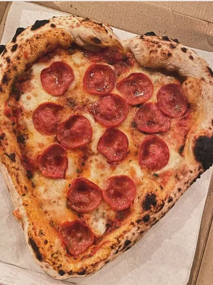 Nothing says "Amore" like a heart-shaped pizza. I love making these for special occasions. This one is a classic pepperoni, fresh from the wood-fired oven with a perfectly leopard-spotted Neapolitan crust.