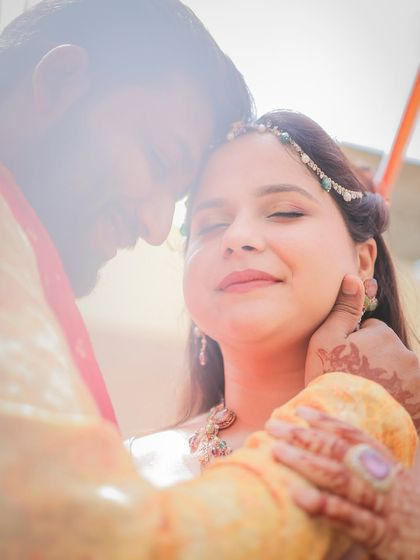 A soft, dreamy portrait of a couple, with the groom gently holding the bride's face.