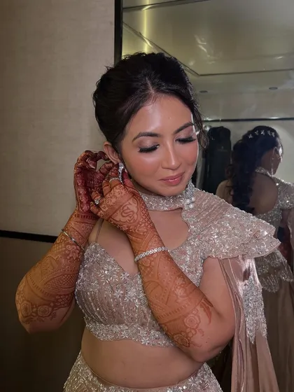 A candid moment of the bride putting on her earrings, her glowing makeup looking perfect from every angle.