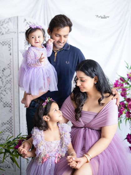 A candid moment where the family's attention is on the older daughter. These natural interactions result in the most authentic family photos.