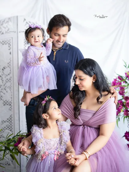 A candid moment where the family's attention is on the older daughter. These natural interactions result in the most authentic family photos.