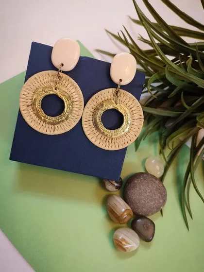 A styled shot of the golden straw braided circle drop earrings, perfect for a nature-inspired look.